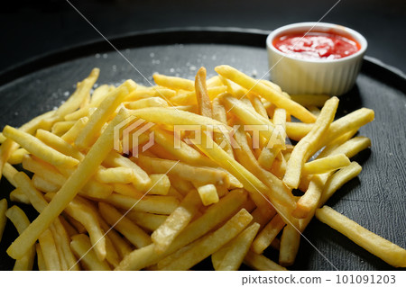 French fries on a dark background, close-up. Fast food French fries on a dark background, close-up. Fast food 101091203