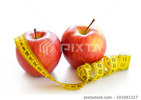 Red apples with measuring tape isolated on white. Healthy lifestyle, diet concept. Close-up Red apples with measuring tape isolated on white. Healthy lifestyle, diet concept. Close-up 101091327