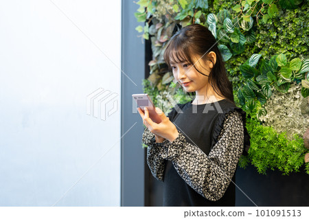 一個操作智能手機的年輕女子 101091513