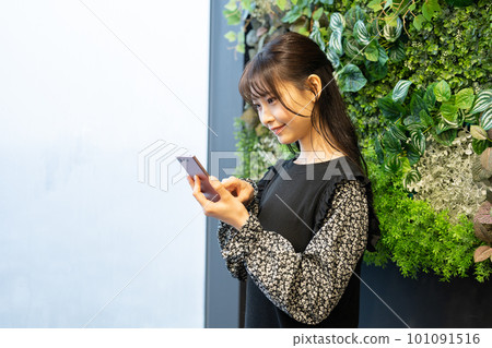 A young woman operating a smartphone A young woman operating a smartphone 101091516