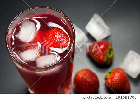 Fresh strawberry cocktail with strawberries and ice cubes on a dark background, close-up. Fresh strawberry cocktail with strawberries and ice cubes on a dark background, close-up. 101091703