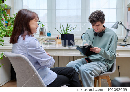 Woman social worker, mentor interviewing, talking to young male in office Woman social worker, mentor interviewing, talking to young male in office 101092669