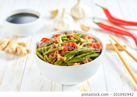 Traditional Chinese food, Szechuan style pork with green beans ginger and hot peppers on a white wooden table. 101092942