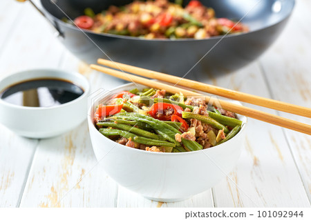 Fragrant spicy Chinese food minced ground pork belly stir fried with pickled yard long beans and red chili peppers on a wooden table. 101092944