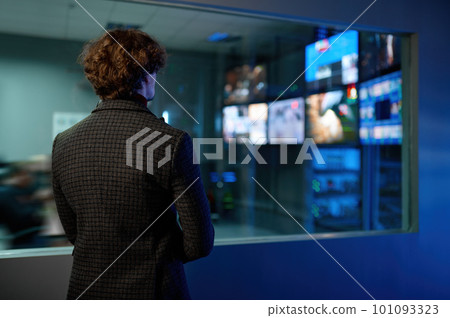 Man looking at computer screen reflection in server room window 101093323