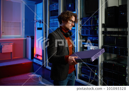 Portrait of it specialist holding hardware in hand standing in server room 101093328