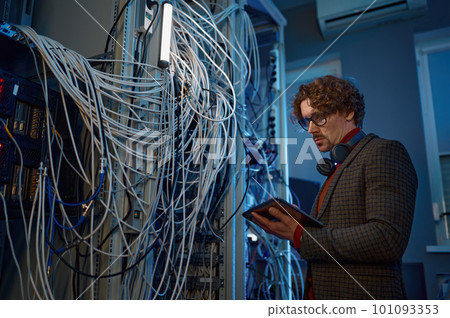 Male IT technical specialist makes a diagnosis in server room Male IT technical specialist makes a diagnosis in server room 101093353