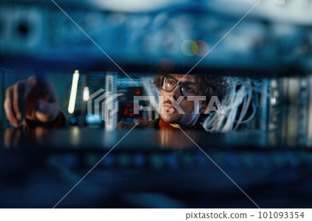 Male IT professional working in server room selective focus Male IT professional working in server room selective focus 101093354