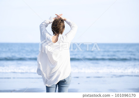 Women who take a deep breath and stretch on the beach Menopause and stress free 101096170