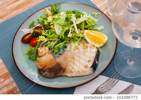 Porbeagle steak with greens salad, tomatoes and lemon 101096772