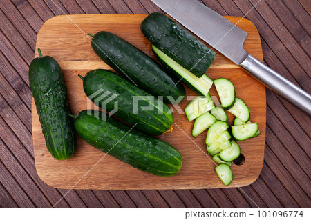 Ripe green cut cucumbers on wooden background Ripe green cut cucumbers on wooden background 101096774