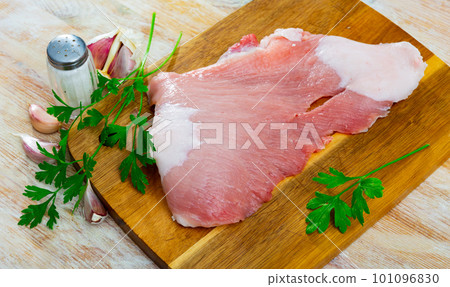 Raw slice of Iberian pork secret on wooden cutting board with seasonings Raw slice of Iberian pork secret on wooden cutting board with seasonings 101096830