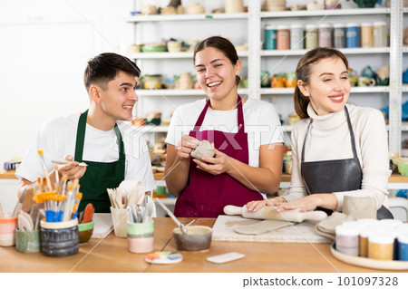 Joyous young man and women sculpting handmade cups Joyous young man and women sculpting handmade cups 101097328