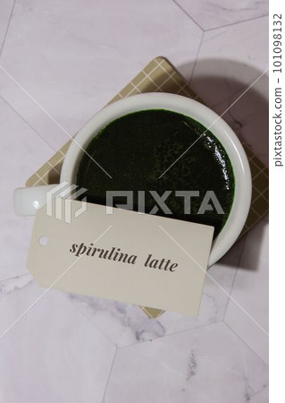 Matcha coffee latte with paper note text SPIRULINA LATTE. Blue-green algae Chlorella and spirulina powder drink. Super powder. Natural supplement of algae. Detox superfood drink cocktail. Food Matcha coffee latte with paper note text SPIRULINA LATTE. Blue-green algae Chlorella and spirulina powder drink. Super powder. Natural supplement of algae. Detox superfood drink cocktail. Food 101098132