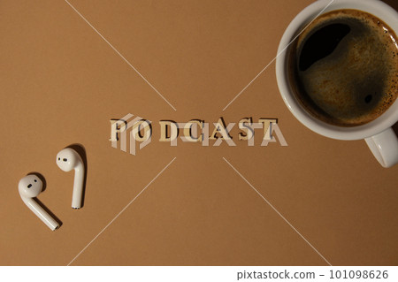 Announcement text PODCAST on beige background with white cup of coffee wireless headphones. Podcasting concept. Listening radio audio healing wellness sound Announcement text PODCAST on beige background with white cup of coffee wireless headphones. Podcasting concept. Listening radio audio healing wellness sound 101098626
