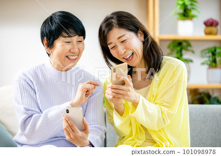觀看智能手機的兩名資深婦女 101098978