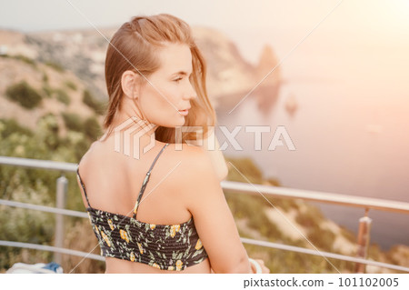 Woman travel sea. Happy tourist enjoy taking picture outdoors for memories. Woman traveler looks at the edge of the cliff on the sea bay of mountains, sharing travel adventure journey Woman travel sea. Happy tourist enjoy taking picture outdoors for memories. Woman traveler looks at the edge of the cliff on the sea bay of mountains, sharing travel adventure journey 101102005