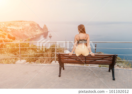 Woman travel sea. Happy tourist enjoy taking picture outdoors for memories. Woman traveler looks at the edge of the cliff on the sea bay of mountains, sharing travel adventure journey Woman travel sea. Happy tourist enjoy taking picture outdoors for memories. Woman traveler looks at the edge of the cliff on the sea bay of mountains, sharing travel adventure journey 101102012