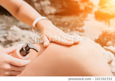 Suntan Lotion. Sexy Woman in bikini apply sun protection cream on her smooth tanned legs. Skin care. Legs on the beach. Close up of female legs with smearing moisturizing lotion. Sunblock concept. Suntan Lotion. Sexy Woman in bikini apply sun protection cream on her smooth tanned legs. Skin care. Legs on the beach. Close up of female legs with smearing moisturizing lotion. Sunblock concept. 101102352