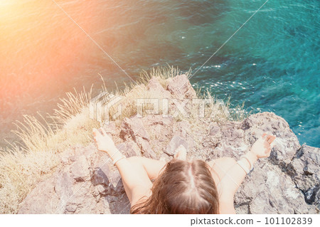 Woman sea yoga. Back view of free calm bliss satisfied woman with long hair standing on top rock with yoga position against of sky by the sea. Healthy lifestyle outdoors in nature, fitness concept. 101102839