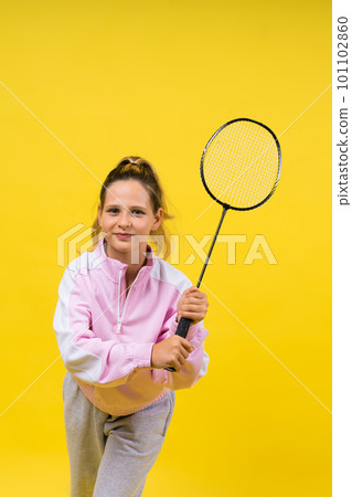 Full length studio photo of ten year old girl holding badminton racket and isolated on yellow. Full length studio photo of ten year old girl holding badminton racket and isolated on yellow. 101102860