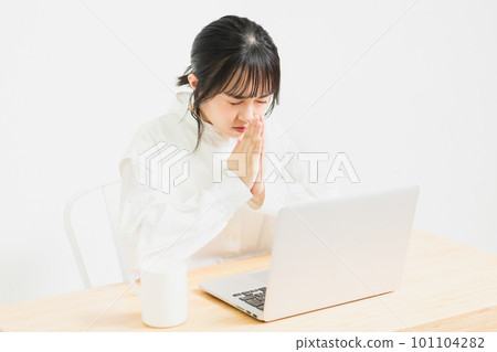 A young woman asking while using a PC 101104282