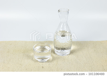 Sake in a glass sake cup and tokkuri 101106480