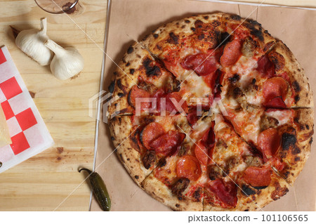 Fresh Pizza on Wooden Table at Restaurant Sliced and Ready to Eat Fresh Pizza on Wooden Table at Restaurant Sliced and Ready to Eat 101106565