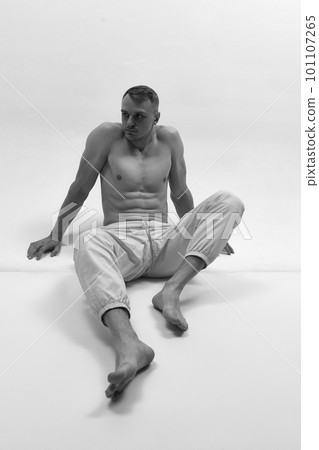 Black and white photo of muscular male fashion model over studio background. Monochrome 101107265