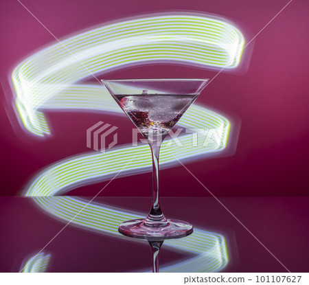Martini cocktail in a glass against the background of neon lights Martini cocktail in a glass against the background of neon lights 101107627