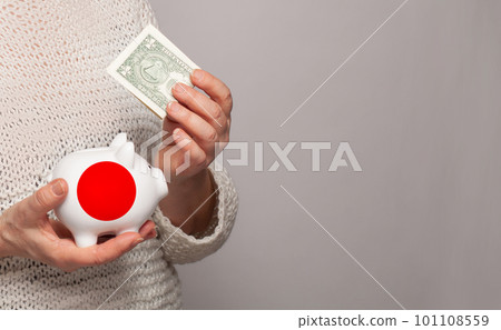 Flag of Japan on money bank in Japanese woman hands.  101108559