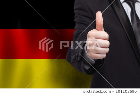 German concept. Businessman showing thumb up on the background of flag of Germany 101108690