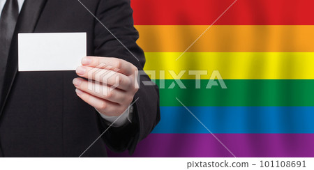 Businessman hand with a white banner on the background of LGBT flag 101108691