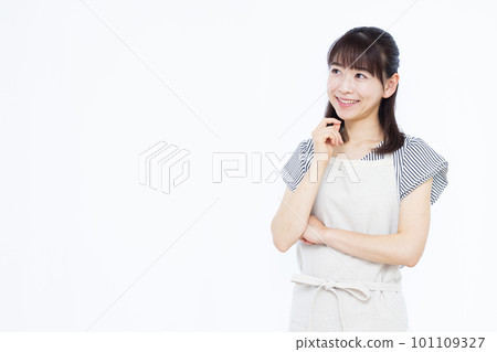 一位三十多歲的家庭主婦圍著圍裙,雙手抱胸微笑思考 一位三十多歲的家庭主婦圍著圍裙,雙手抱胸微笑思考 101109327