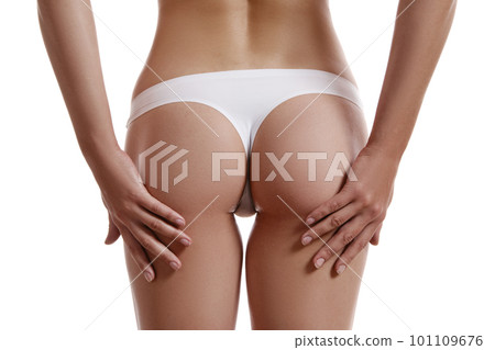 Perfect, slim, young body of a girl in white underwear posing back, isolated on white. Plastic surgery and aesthetic cosmetology concept. Close-up. Perfect, slim, young body of a girl in white underwear posing back, isolated on white. Plastic surgery and aesthetic cosmetology concept. Close-up. 101109676