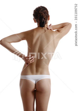 Woman in panties touching her spine, posing standing back to the camera, isolated on white. Plastic surgery, aesthetic cosmetology concept. Close-up. Woman in panties touching her spine, posing standing back to the camera, isolated on white. Plastic surgery, aesthetic cosmetology concept. Close-up. 101109732