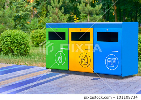 Ecology. Separate waste containers for plastic, paper and glass in a summer park 101109734