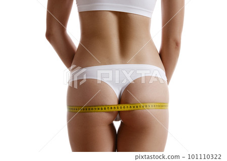 Perfect body of girl in white underwear measuring herself, posing back, isolated on white. Plastic surgery, aesthetic cosmetology concept. Close-up. 101110322