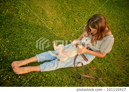 Dog Parson Russell Terrier breed is playing in green park with his owner. Summer time or beginning of autumn. Nature. Pet care and training concept. Dog Parson Russell Terrier breed is playing in green park with his owner. Summer time or beginning of autumn. Nature. Pet care and training concept. 101110427