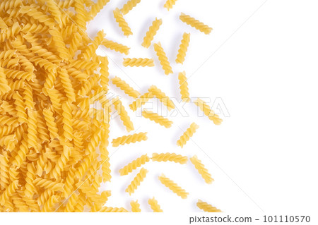 Scattered raw pasta fusilli isolated on white background. Food background, italian cuisine Scattered raw pasta fusilli isolated on white background. Food background, italian cuisine 101110570
