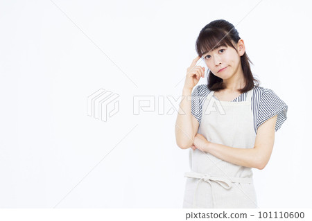 Housewife in her thirties wearing an apron holding her head in front of a white background Housewife in her thirties wearing an apron holding her head in front of a white background 101110600