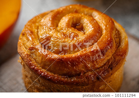 Fresh baked sweet swirl bun roll on serving board Fresh baked sweet swirl bun roll on serving board 101111294