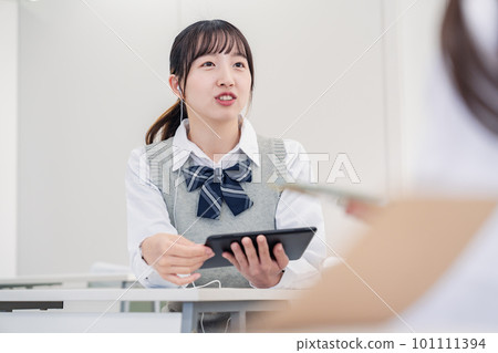 一名高中生使用翻譯應用程序與一名國際學生交流 101111394