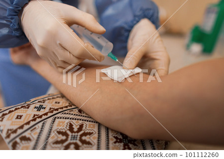 Doctor in medical gloves inject a flu vaccine into a patient's vein. Close-up 101112260
