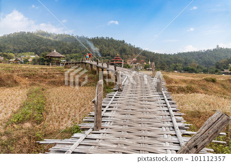 Tourist walking on the Buddha bamboo bridge or Boon Ko Ku So stretches 800 meter long split-bamboo walkway across rice fields and up to a small temple. Tourist walking on the Buddha bamboo bridge or Boon Ko Ku So stretches 800 meter long split-bamboo walkway across rice fields and up to a small temple. 101112357