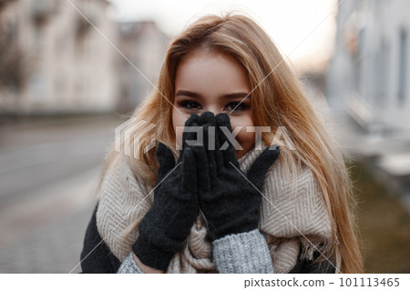 Charming funny young woman with beautiful eyes laughs and covers her face with her hands. Cheerful stylish girl. 101113465