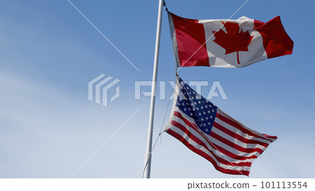 canada and usa flags fluttering in the wind on blue sky copy space blue sky background canada and usa flags fluttering in the wind on blue sky copy space blue sky background 101113554