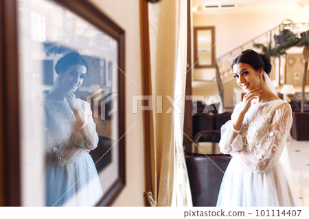 Beautiful bride in fashion wedding dress with a long luxury veil. The stunning young bride is incredibly happy. 101114407