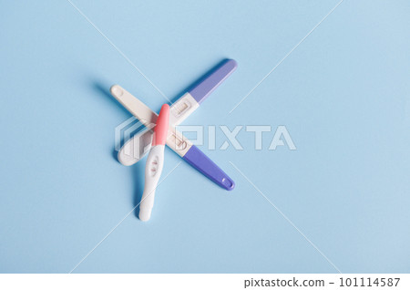 Flat lay composition with pregnancy tests stacked on blue pastel background with copy ad space. Women's health, fertility and rapid pregnancy diagnostics concept Flat lay composition with pregnancy tests stacked on blue pastel background with copy ad space. Women's health, fertility and rapid pregnancy diagnostics concept 101114587