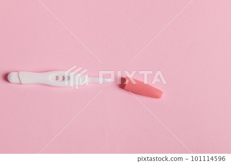 Flat lay with a pregnancy test showing positive result between HCG hormone in female urine, isolated on pink background. Rapid diagnosis of pregnancy. Women's health and fertility concept. Copy space 101114596